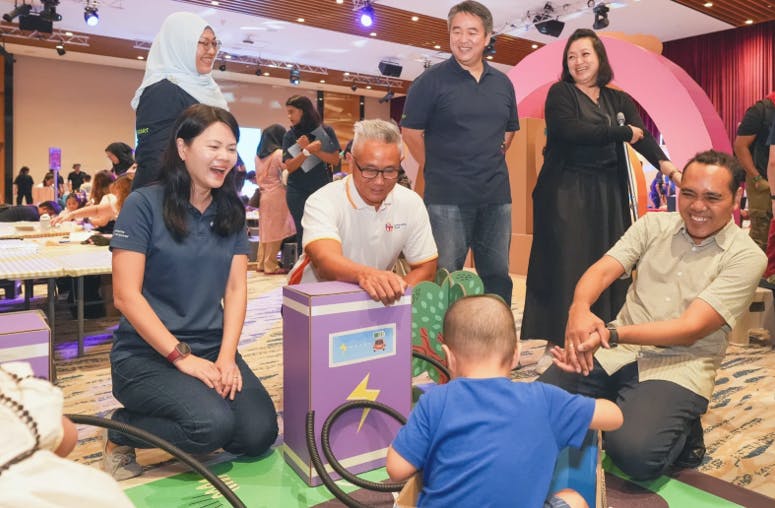 SP Chief Human Resource Officer Yew Lay Teng (far left) with Zhulkarnain Abdul Rahim (far right), Minister of State for Social and Family Development and Foreign Affairs engaging children at the Play It Forward Festival which supports early childhood development through play-based learning