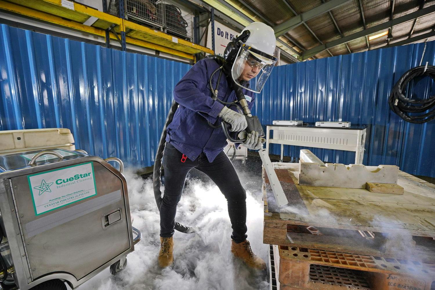Cuestar project manager Neo Hong Giap demonstrating dry ice blasting on a metal strip