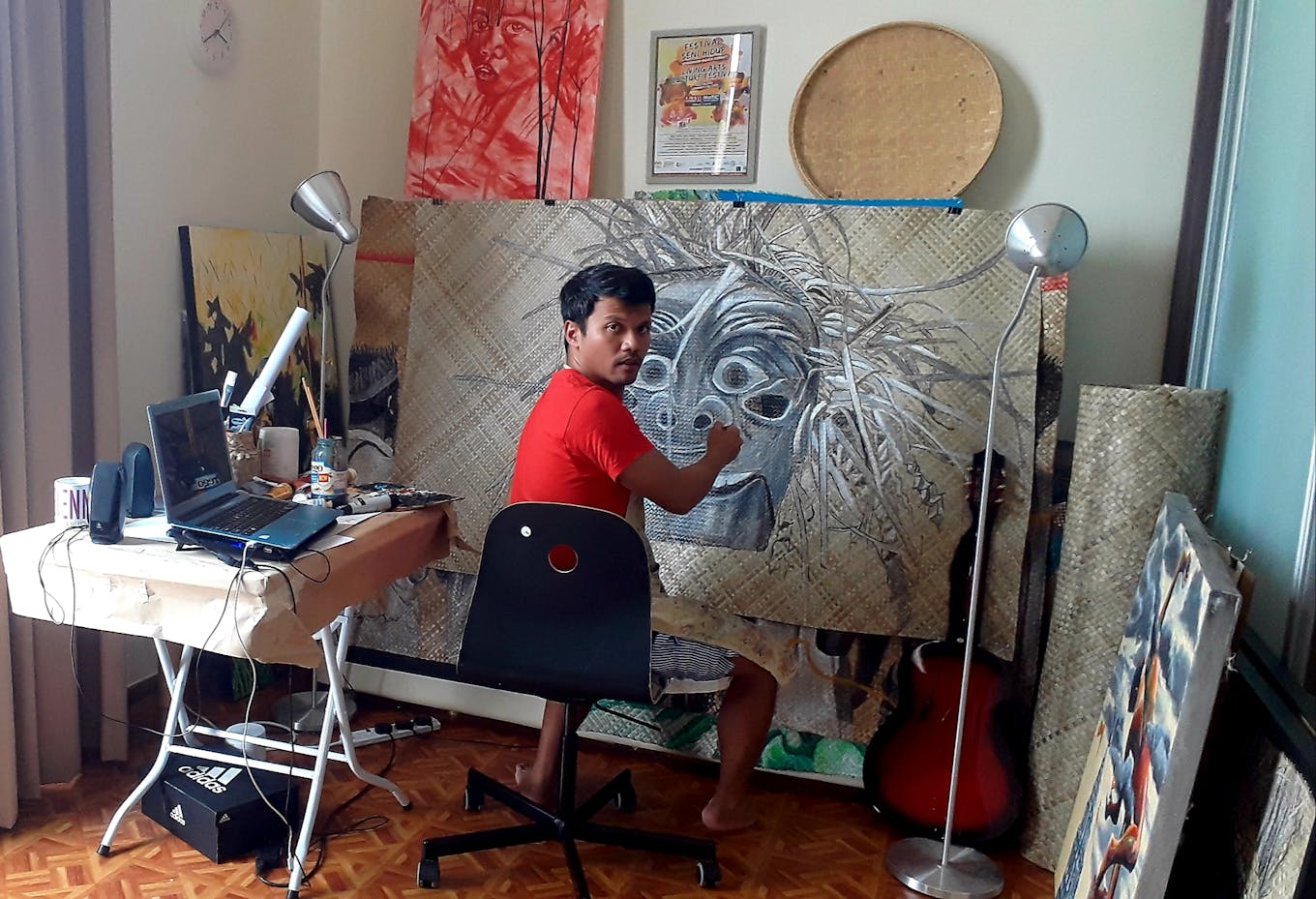 Shaq Koyok painting at home