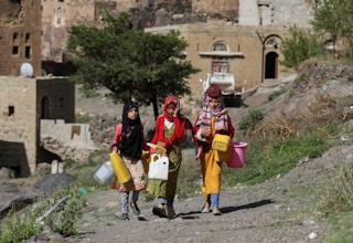 Girls walk as they carry jerrycans to fetch water