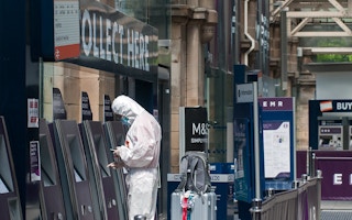traveller in a protective suit  withdraws cash coronavirus