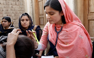 A female doctor with the International Medical Corps examines a woman patient at a mobile health clinic in Pakistan