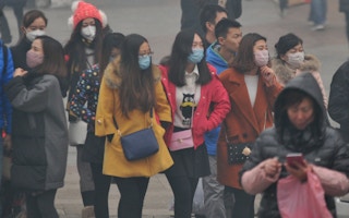 pedestrians walking in smog in shenyang city china