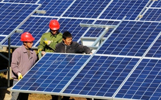 Chinese workers install solar panels
