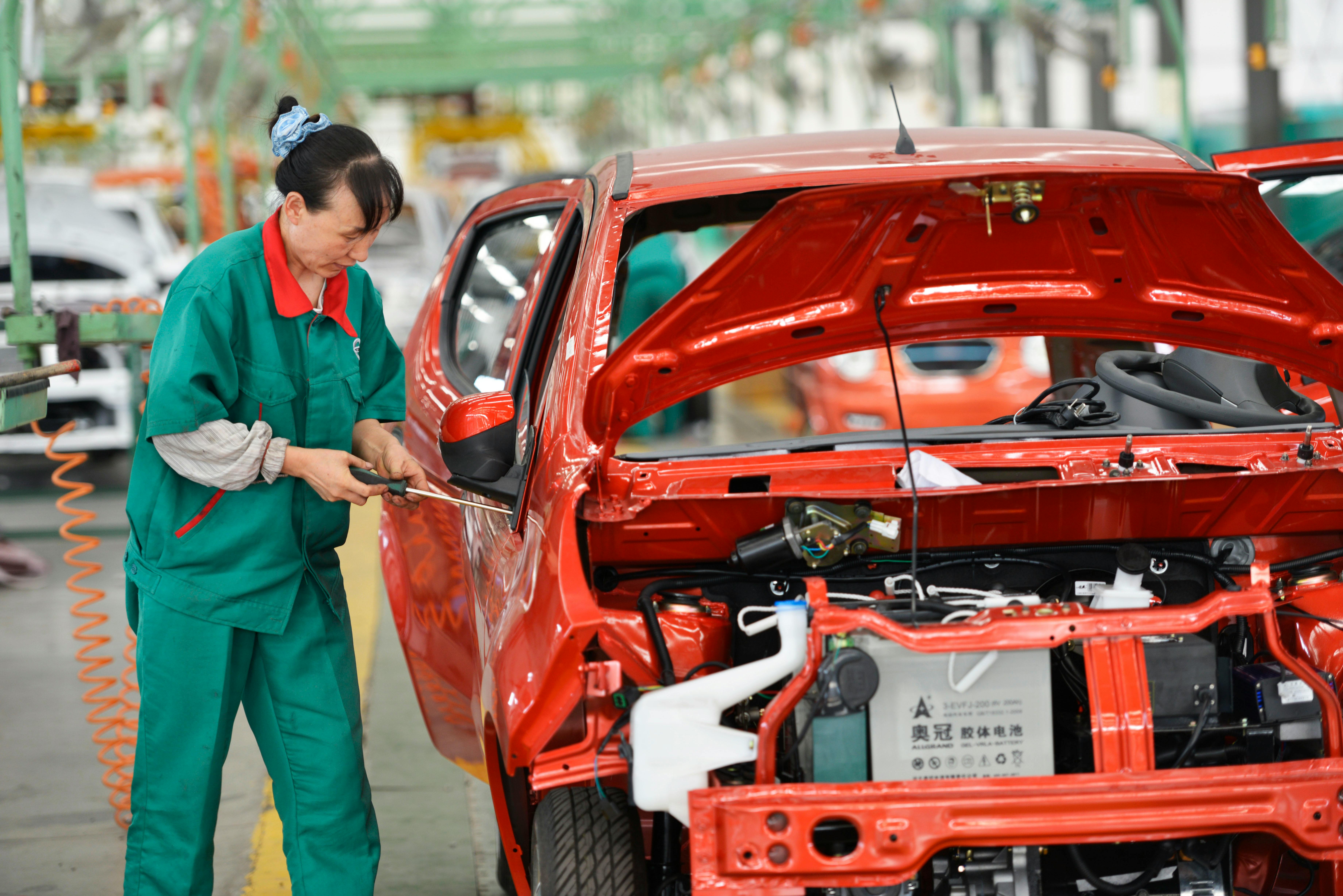 Chinese worker assembles EV