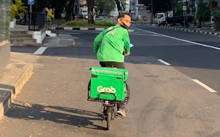 A GrabFood driver riding an e-scooter in Little India, Singapore.