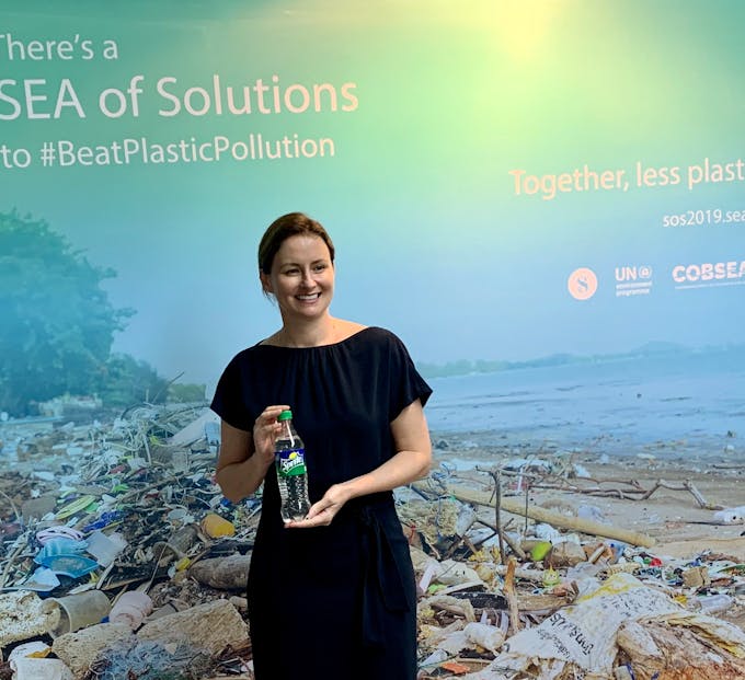 Belinda Ford of Coca-Cola poses at the SEA of Solutions event with the new transparent Sprite bottle, which is easier to recycle and made from recycled plastic. Image: Eco-Business