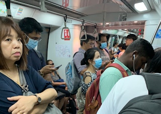 Commuters on a train in Singapore, some wearing disposable surgical masks as a protection measure from the Coronavirus. Image: Eco-Business