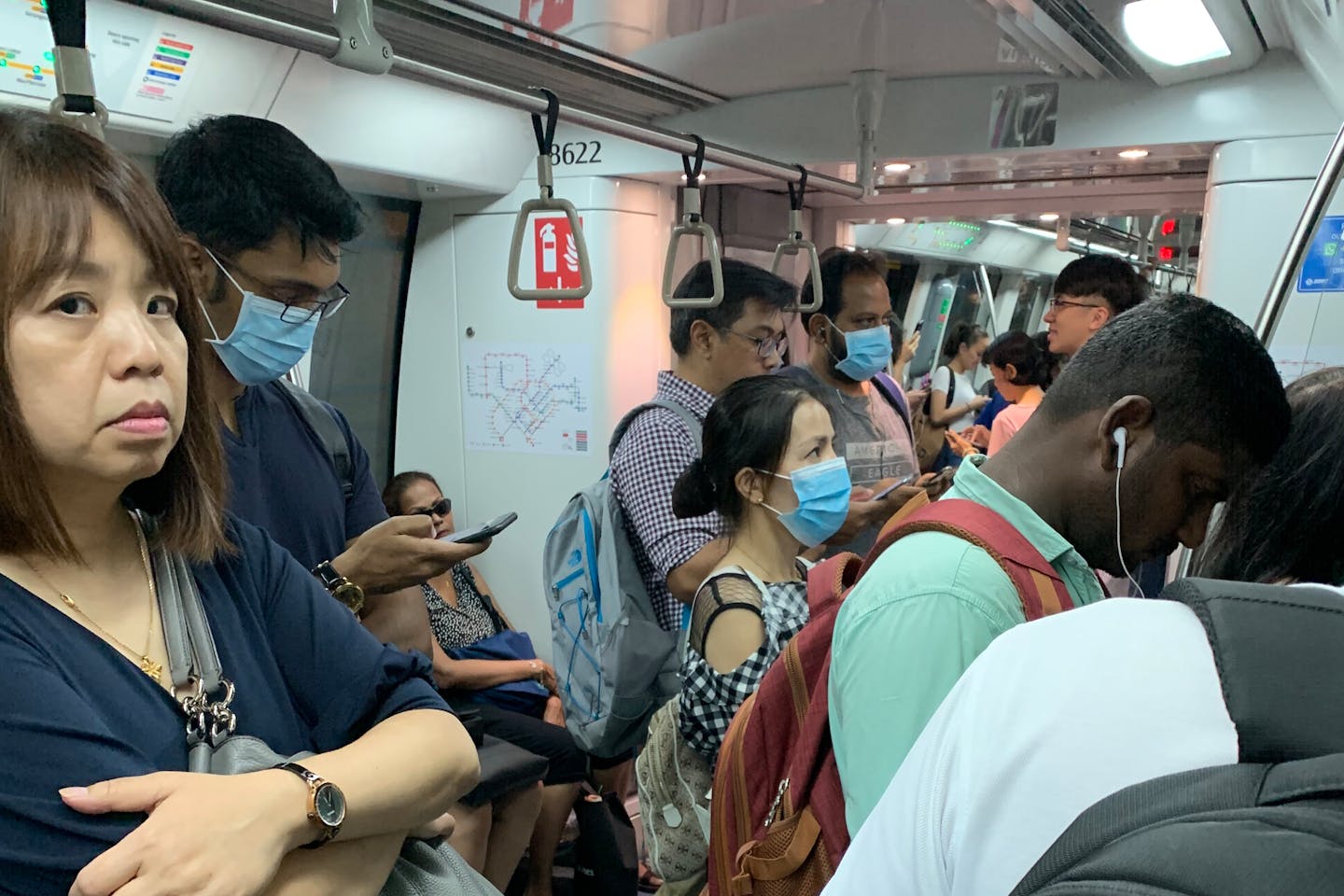 Commuters on a train in Singapore, some wearing disposable surgical masks as a protection measure from the Coronavirus. Image: Eco-Business