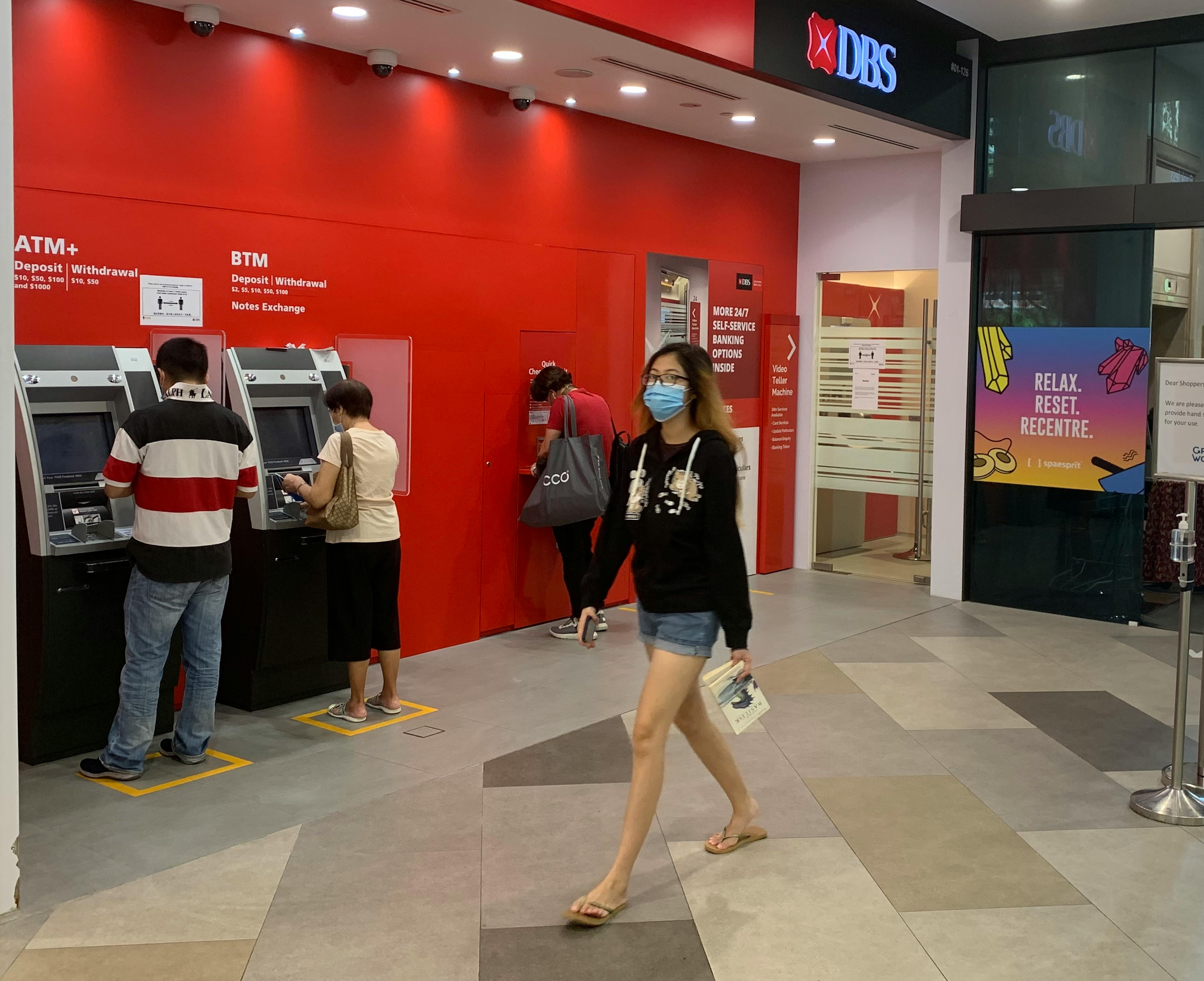 People using ATM machines in Singapore. Image: Robin Hicks/Eco-Business