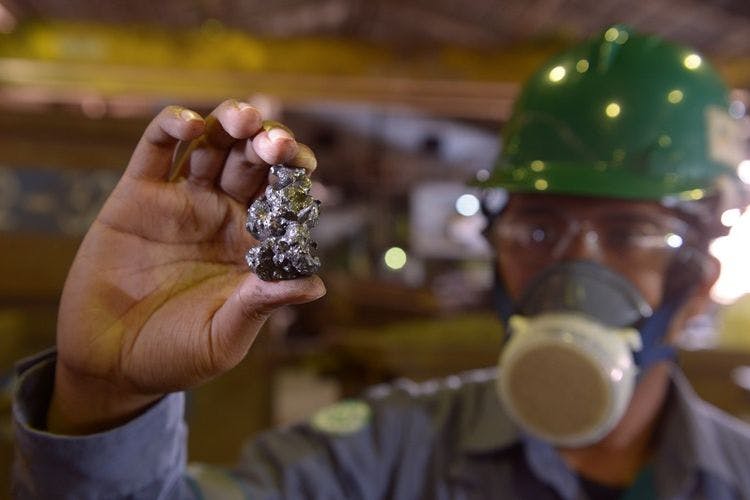 An Indonesian miner holds up a nickel ore
