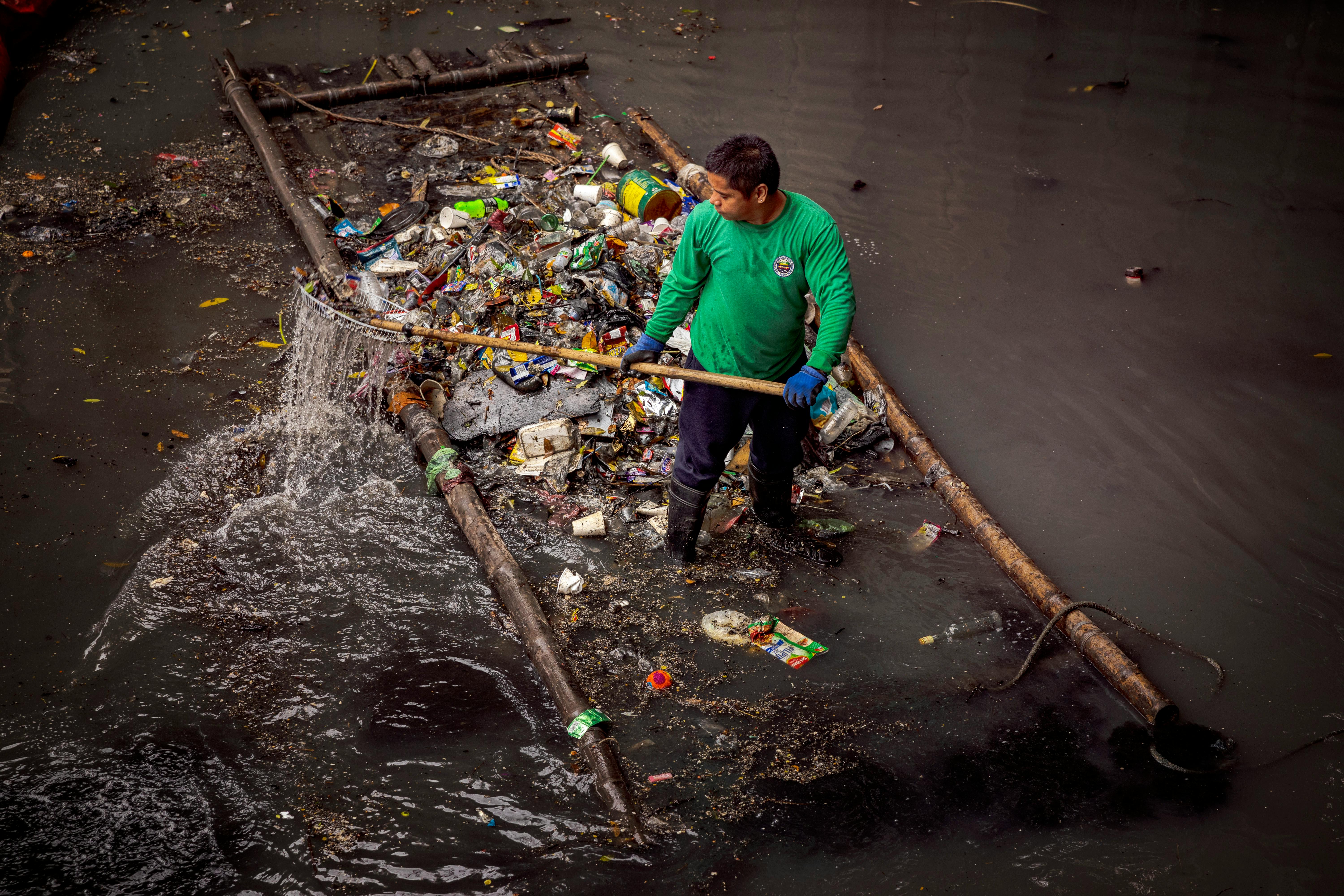 A river patroller collects plastic waste