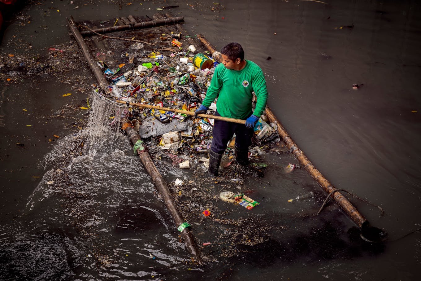 A river patroller collects plastic waste