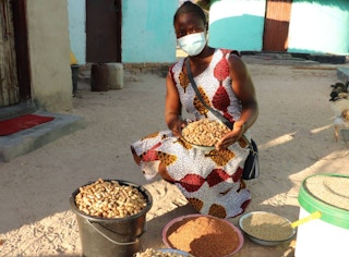 Farmer Mavis Gofa poses with grains she produced from her hometown in Mutoko, northeastern Zimbabwe