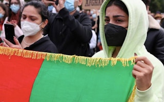 woman holds an Afghan flag