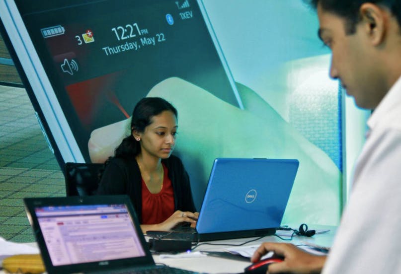 Employees work on their laptops at the Start-up Village, India