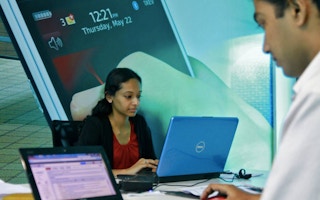 Employees work on their laptops at the Start-up Village, India