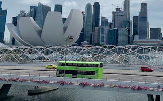 A bus heads over a bridge at Marina Bay.