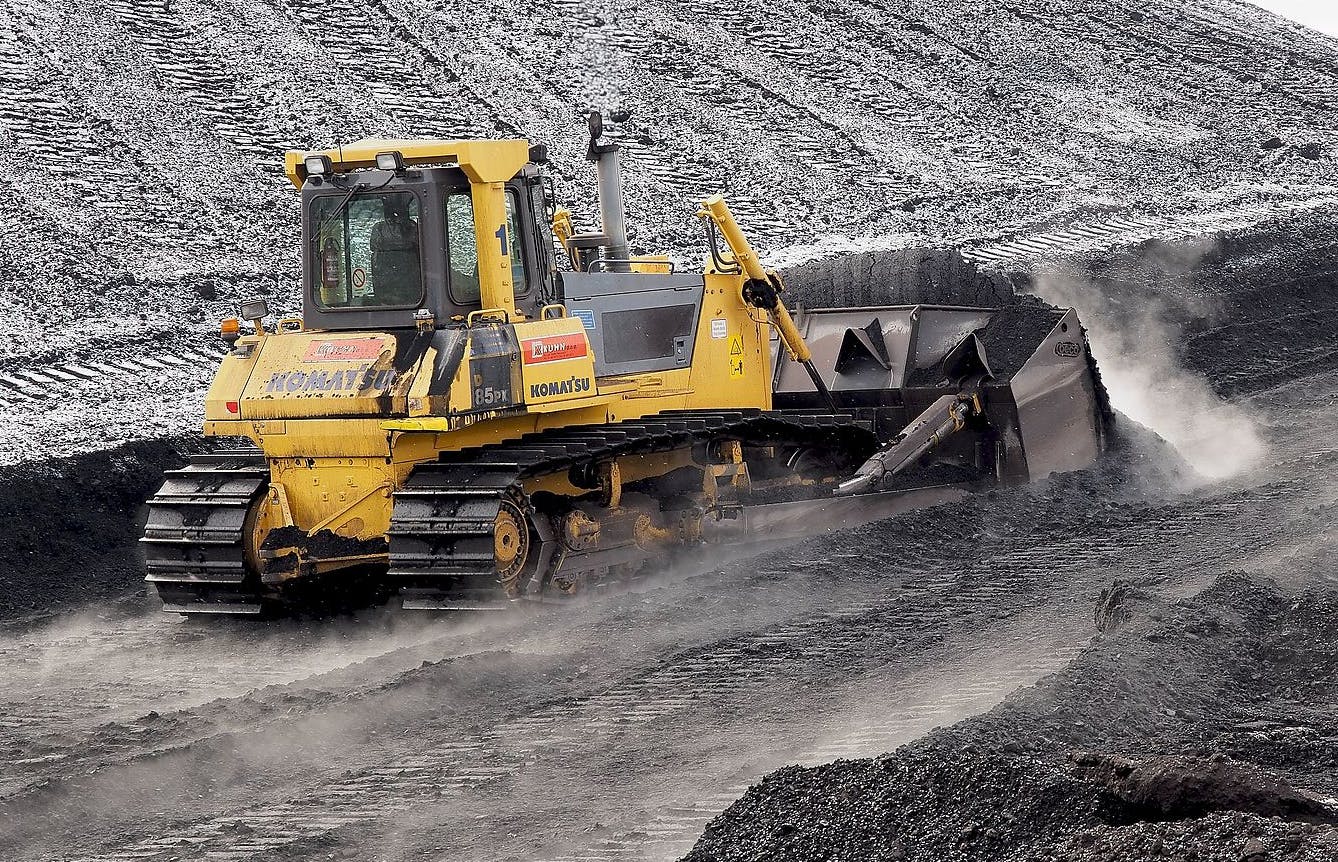 a bulldozer pushing indonesian coal