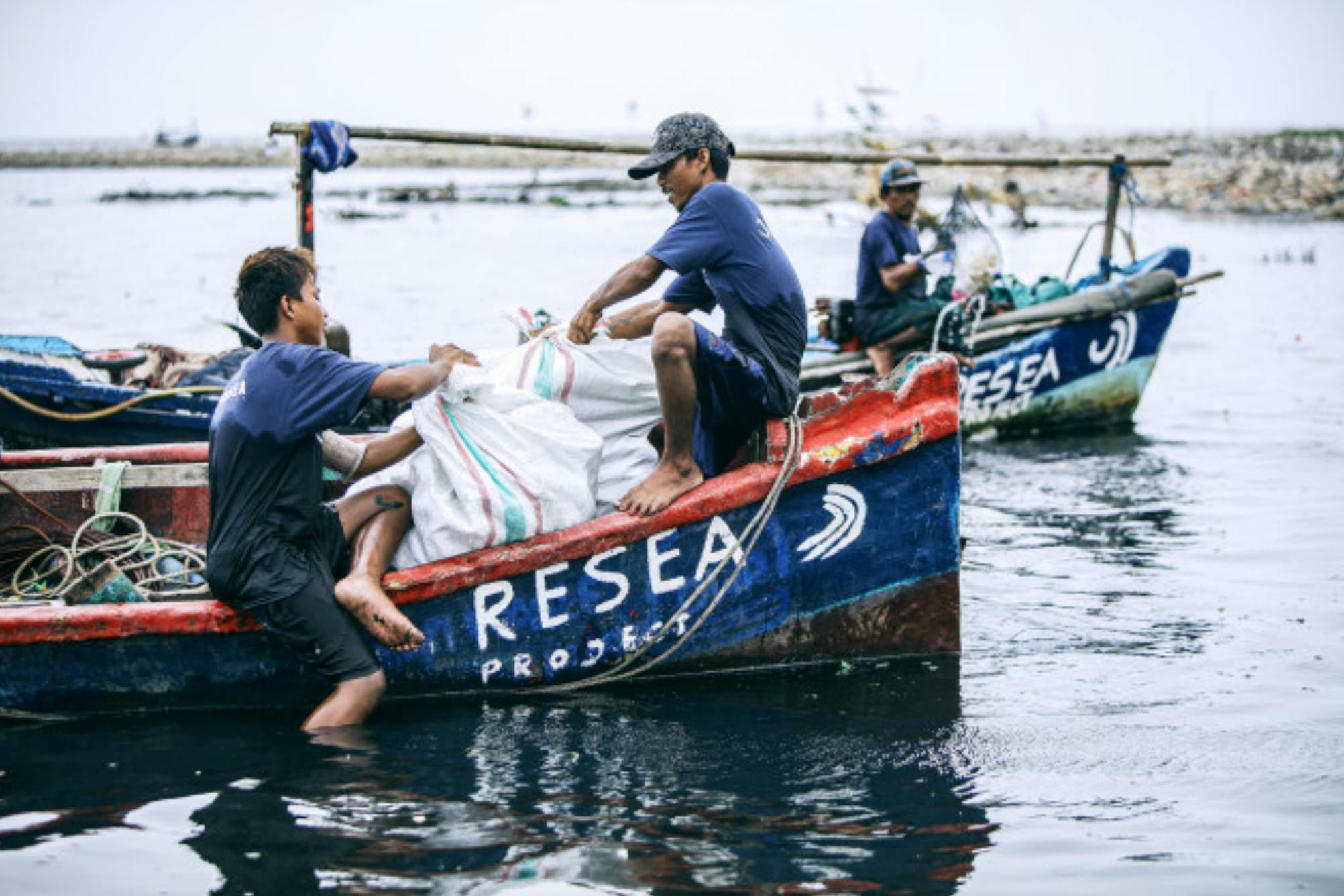 Fishermen sponsored by ReSea Project collect plastic from a waterway in Indonesia