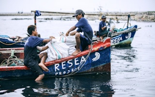 Fishermen sponsored by ReSea Project collect plastic from a waterway in Indonesia