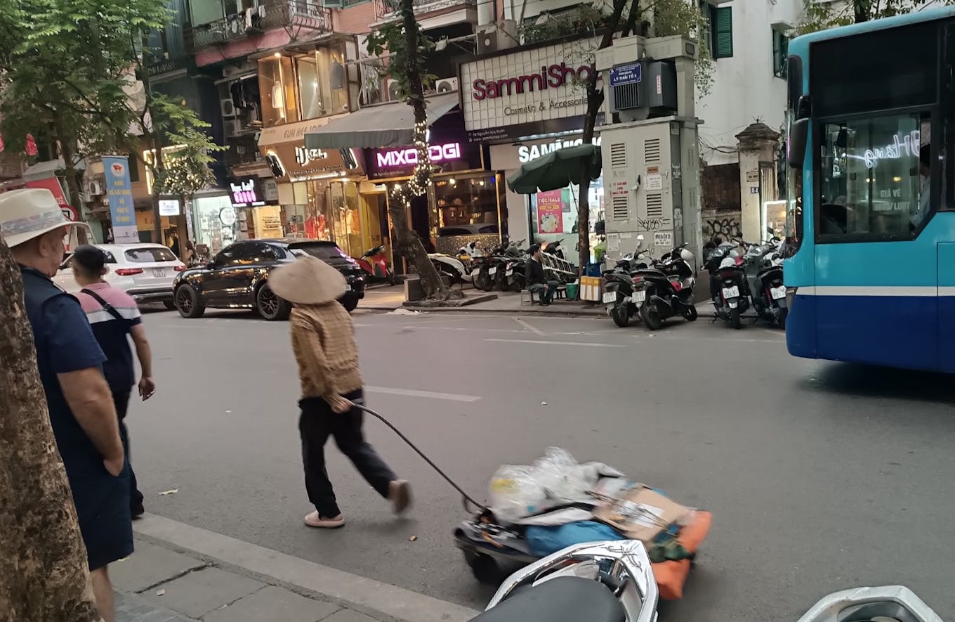 A waste picker walks down the street in Hanoi
