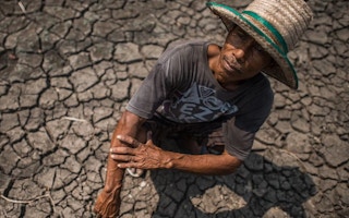 A farmer tends to his parched field in Thailand