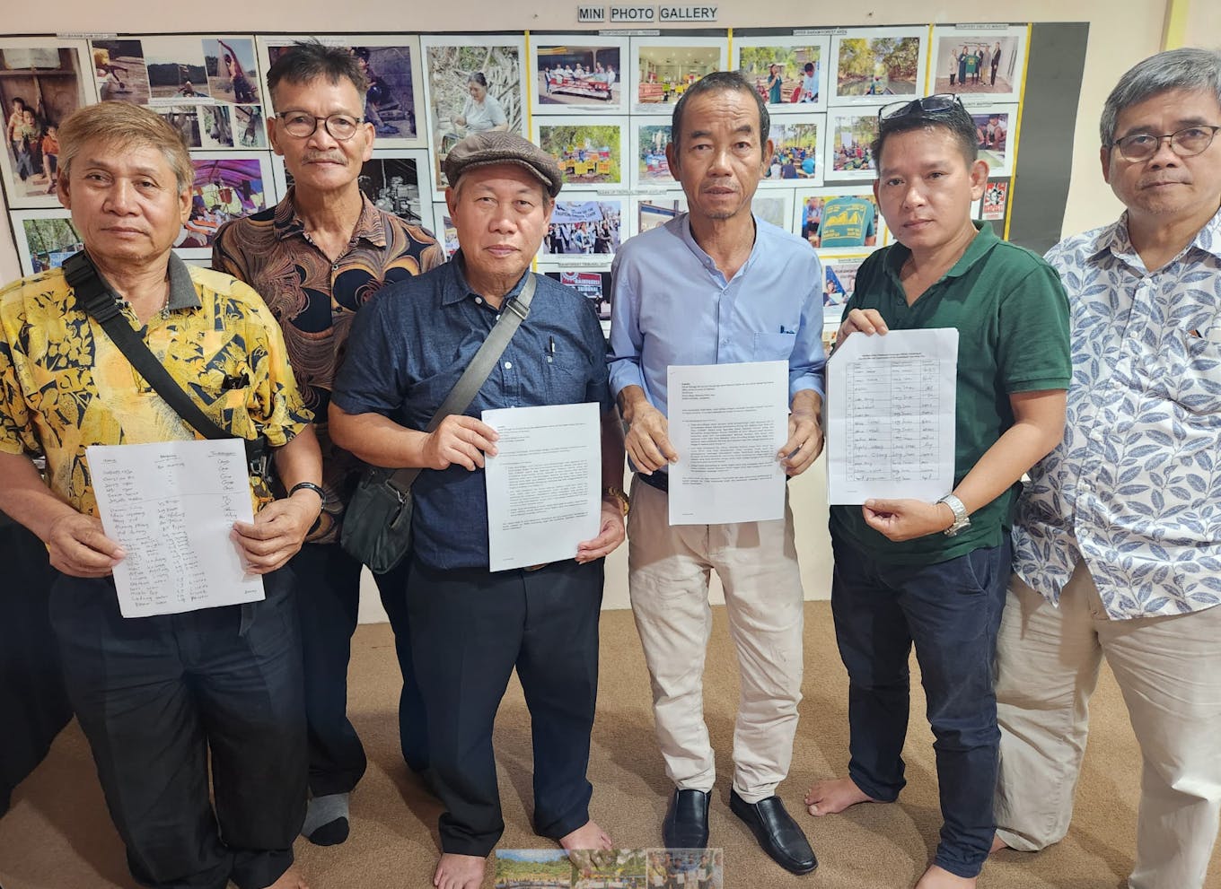Men from Indigenous tribes hold a signed petition to stop the construction of a cascading dam in Sarawak