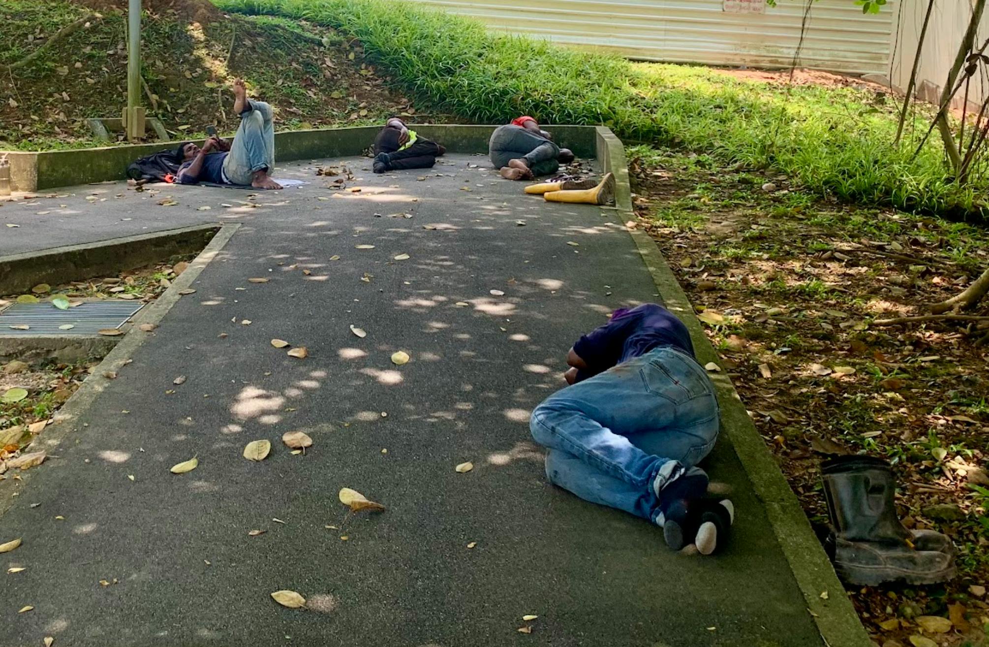 Workers rest in the shade outside a construction site in Singapore.