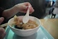 A single-use plastic soup spoon in use in HK
