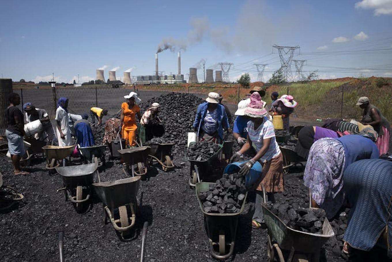 Women in South Africa fill wheelbarrows with free coal in 2015.