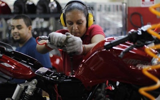 a woman assembles motorbike