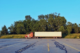 A freight truck sits in a parking lot.