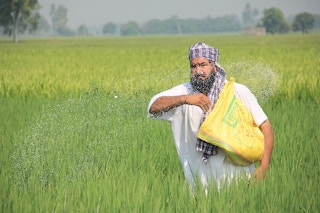 farmer using fertiliser on field