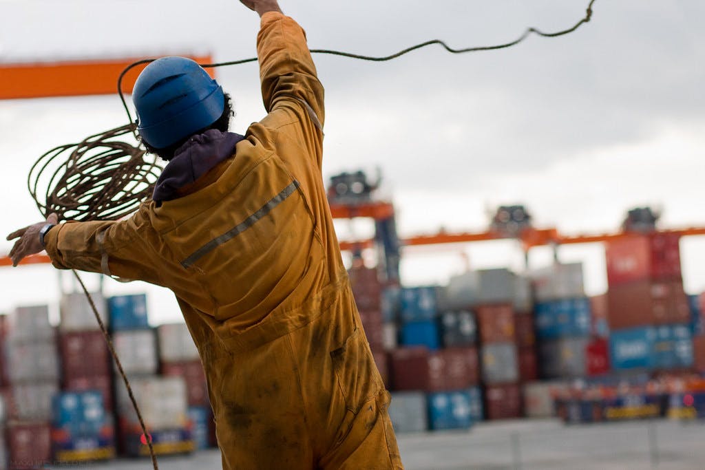Filipino seaman throwing the ball of the mooring rope