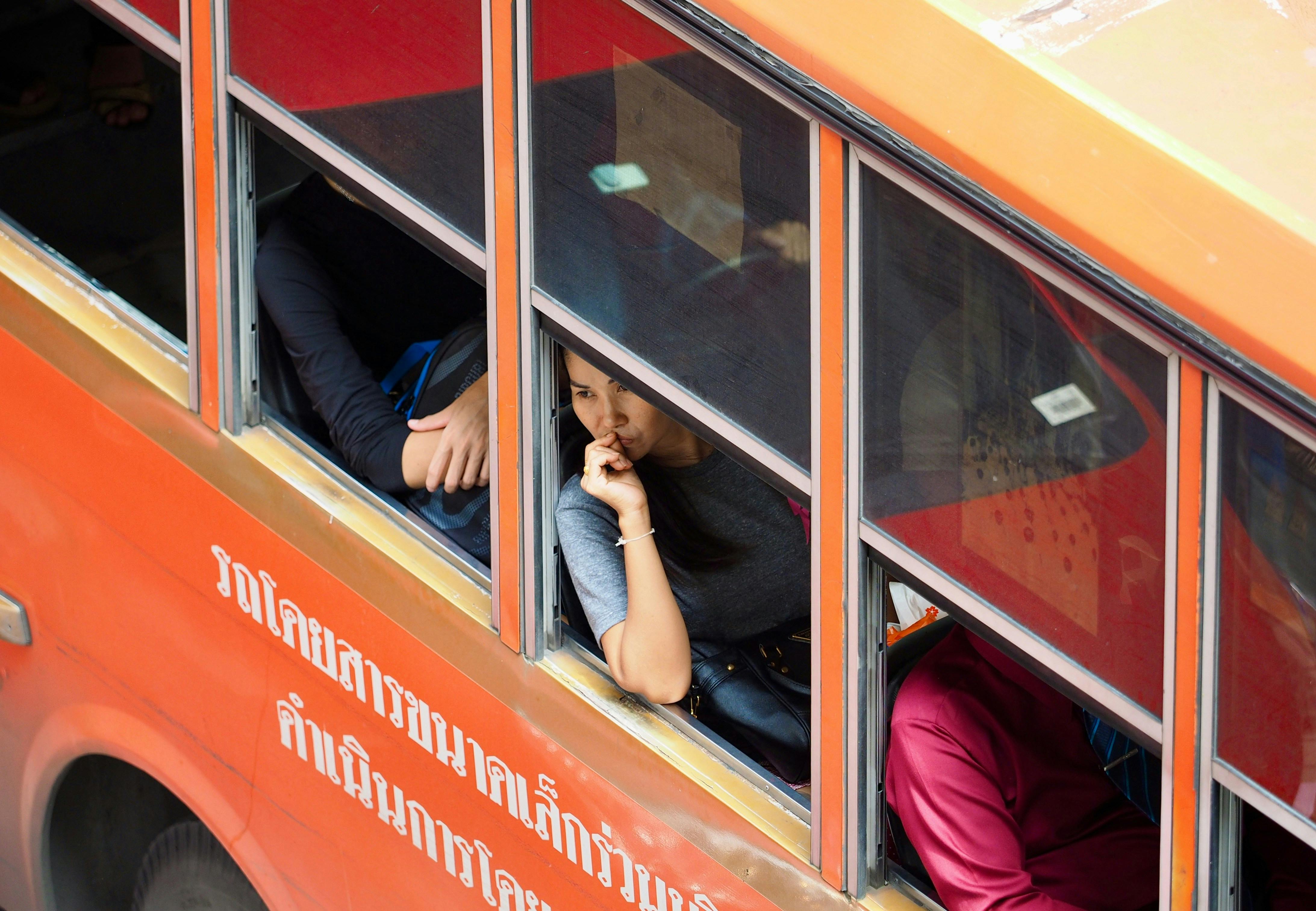 A pasenger seen sitting in an iconic Bangkok bus.