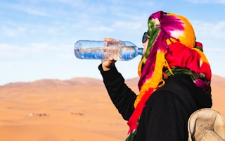 Traveller drinks water from a plastic bottle