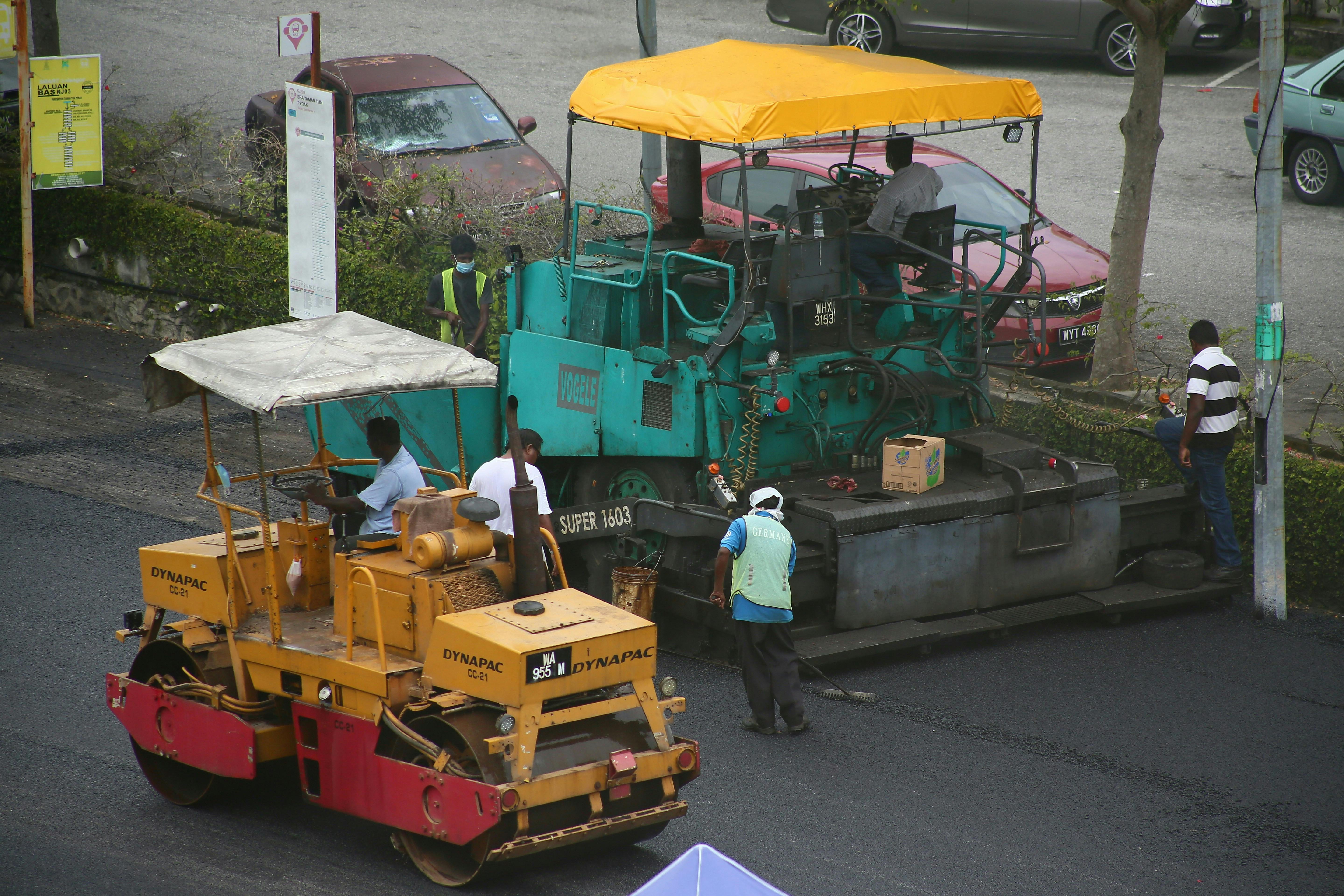Road construction work by workers with machinery in Malaysia