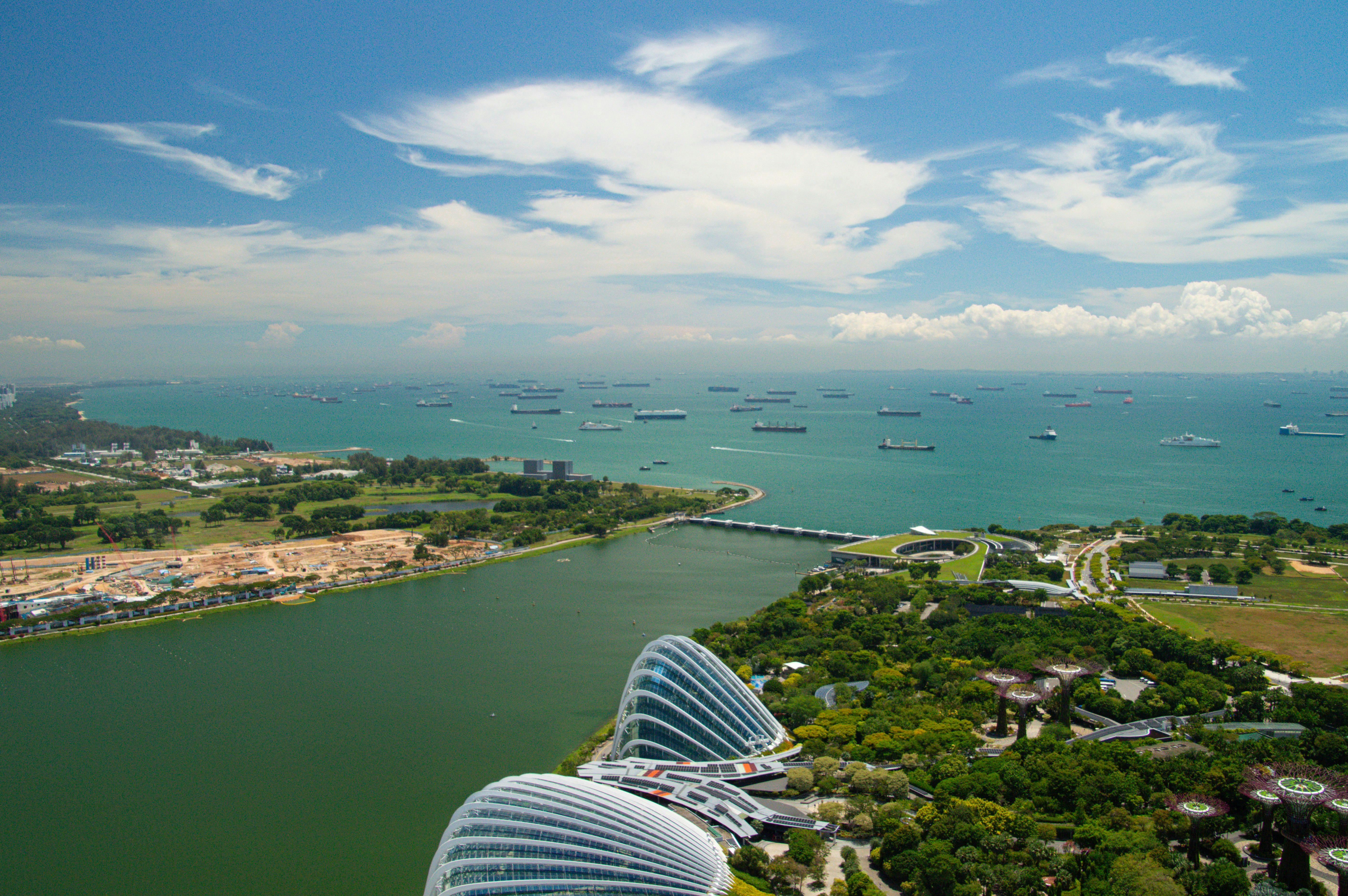An aerial view of Singapore's marina bay featuring iconic architecture and bustling sea traffic.