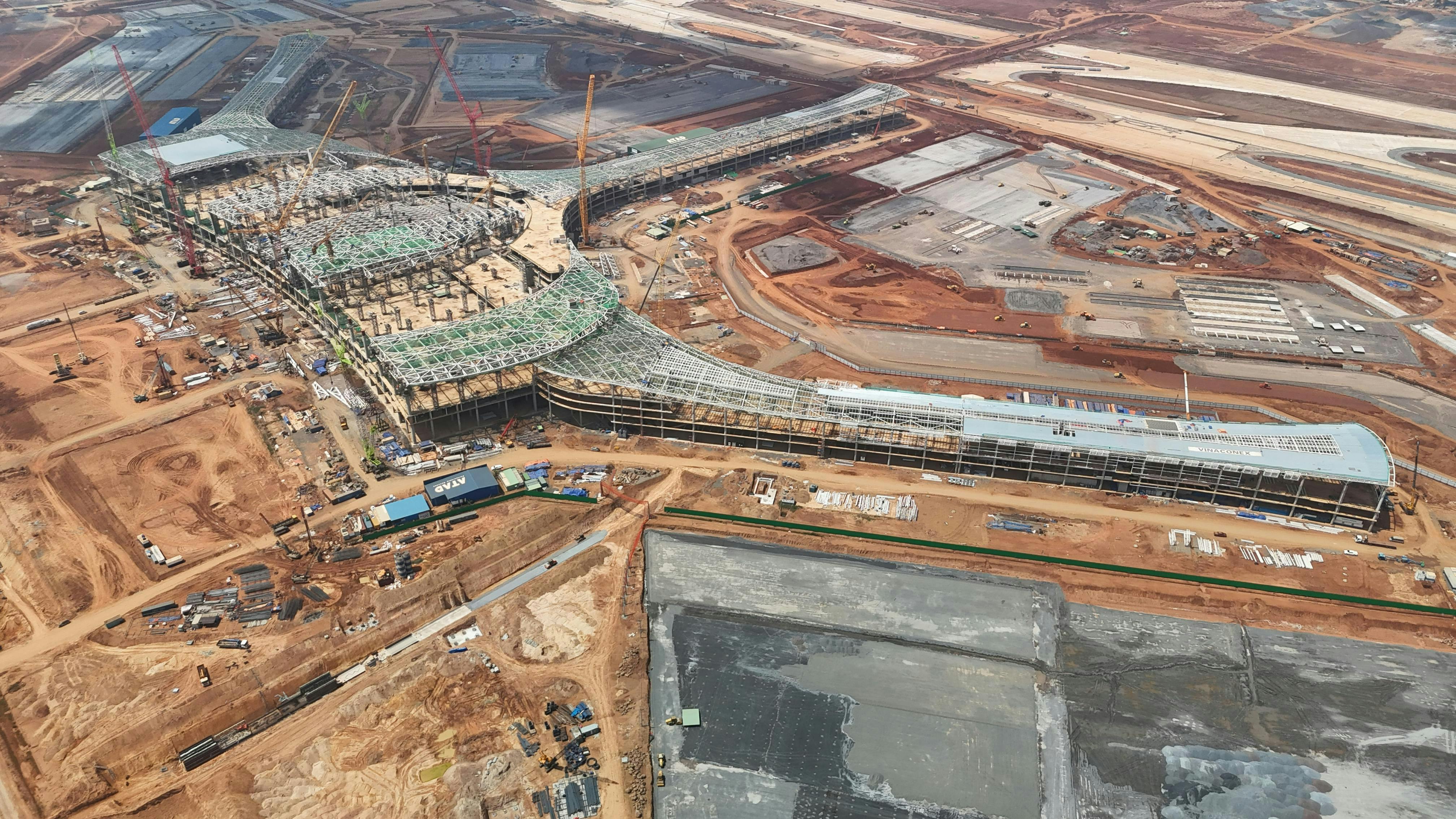 Expansive aerial shot of a construction site with cranes and building foundations in Dong Nai, Vietnam