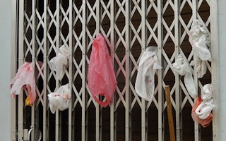 Single-use plastic bags are stuffed into a grate door in Little India, Singapore. Only 6 per cent of the city-state's plastic waste was recycled last year. Image: Michael Coghlan/Flickr