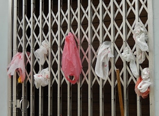 Single-use plastic bags are stuffed into a grate door in Little India, Singapore. Only 6 per cent of the city-state's plastic waste was recycled last year. Image: Michael Coghlan/Flickr