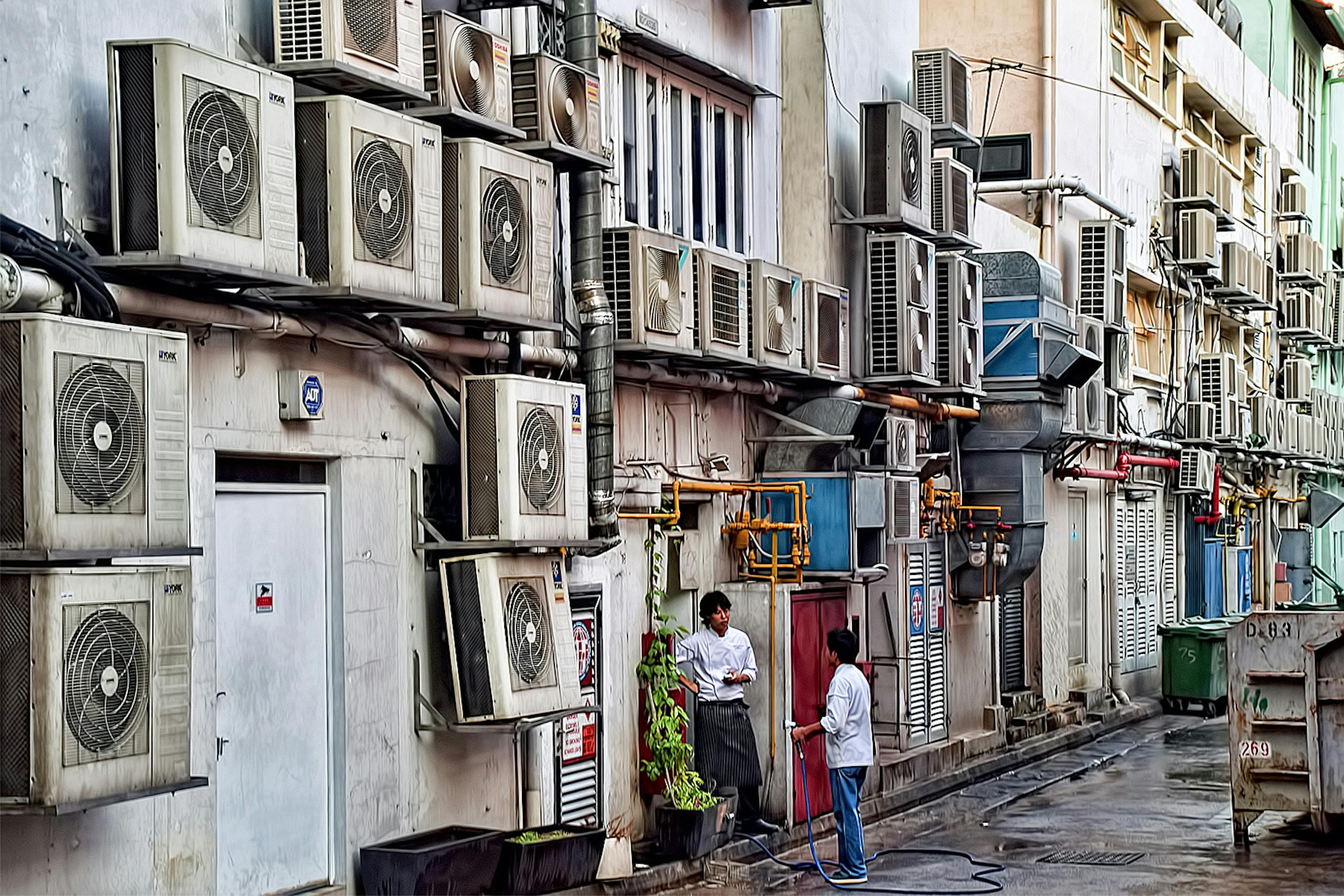 Air conditioner compressors occupy almost all the open space available on the wall of a building in Boat Quay, Singapore