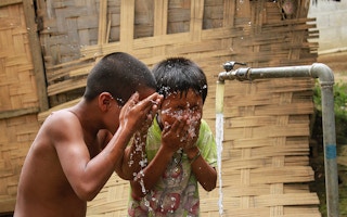 kids cool off with clean water in LAO