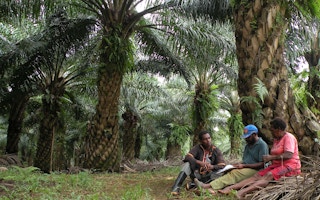 palm oil plantation workers take a break