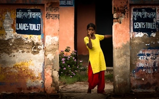 little girl stands at toilet in Fatehpur Sikri, India