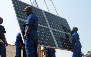 men installing solar panels in Rwanda.