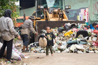 A child finds a teddy bear in a waste bank in Depok, West Java. 