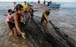 children help pull fishing nets in Indonesia