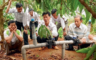 Vietnamese coffee farmers examine water management system